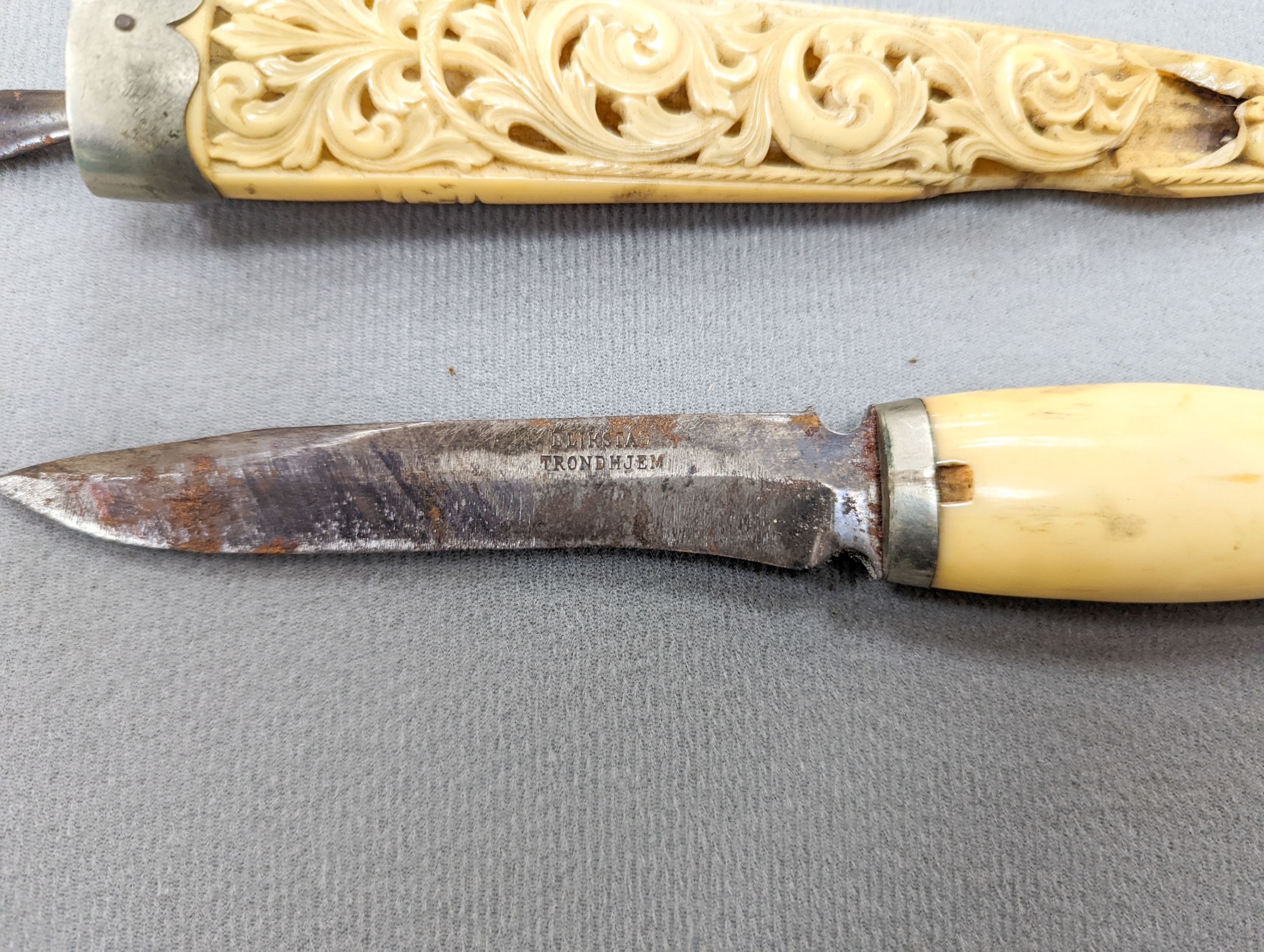 An antique Norwegian marine ivory hunting knife, with carved and pierced scabbard and leather outer sheath, the blade signed Blikstad, Trondhjem, scabbard damaged, overall 26.5cm.